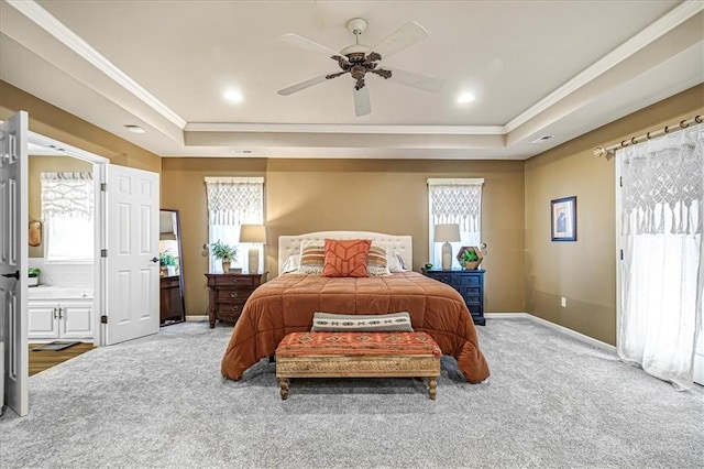 carpeted bedroom with multiple windows, a tray ceiling, and ornamental molding