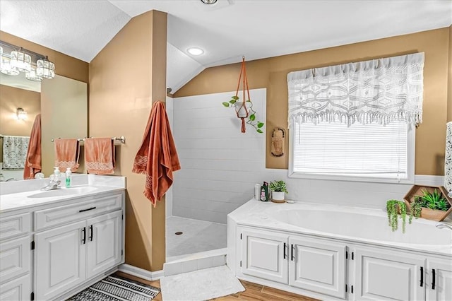 bathroom with vanity, hardwood / wood-style flooring, vaulted ceiling, and shower with separate bathtub