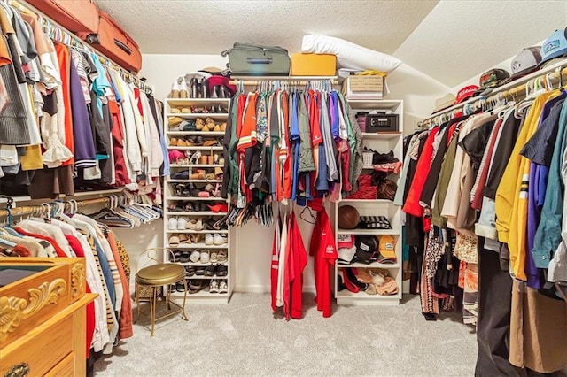 spacious closet featuring vaulted ceiling and light colored carpet