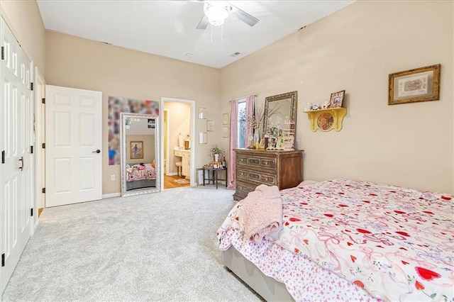 bedroom featuring light carpet, a closet, ceiling fan, and ensuite bathroom