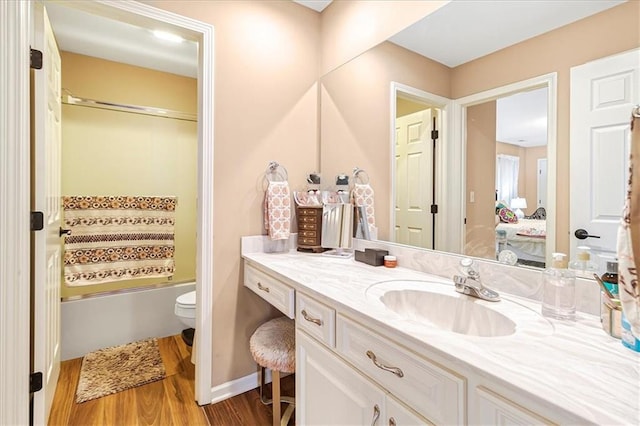 full bathroom featuring enclosed tub / shower combo, hardwood / wood-style floors, vanity, and toilet