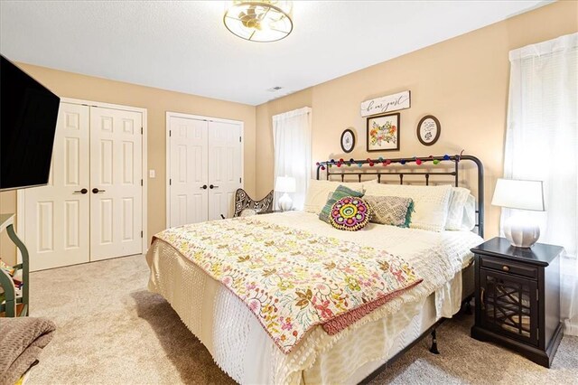 carpeted bedroom with two closets