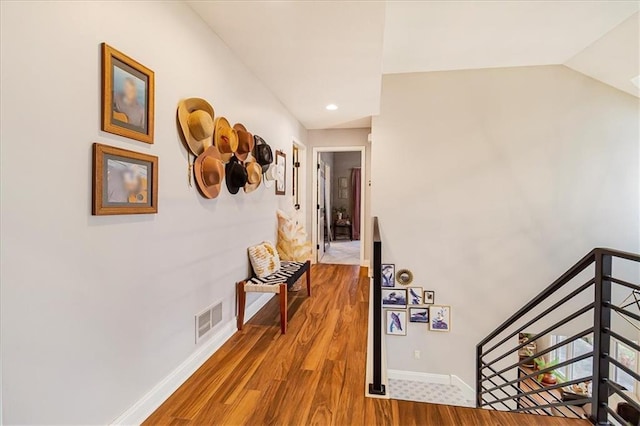 hallway featuring hardwood / wood-style flooring and vaulted ceiling