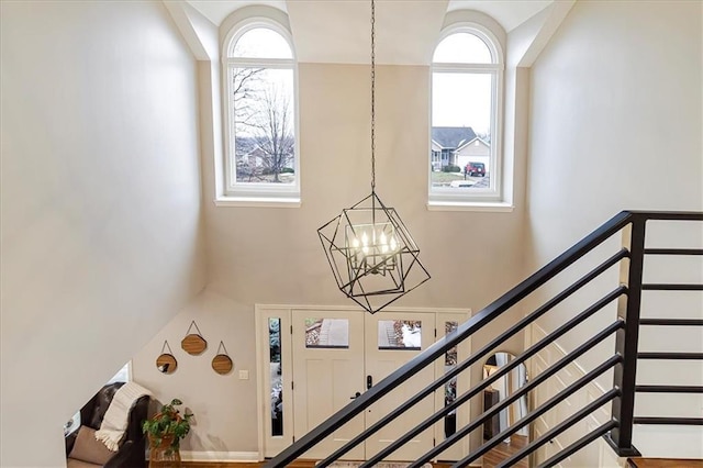 stairway with a towering ceiling and a notable chandelier