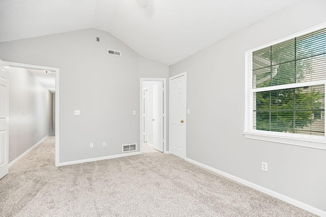 unfurnished bedroom with lofted ceiling and light carpet