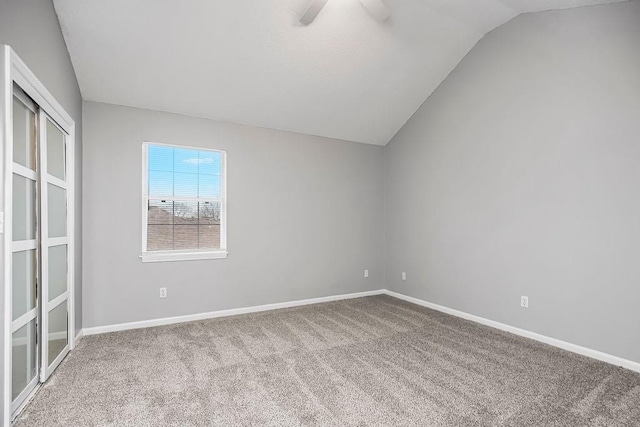 carpeted spare room with vaulted ceiling and ceiling fan