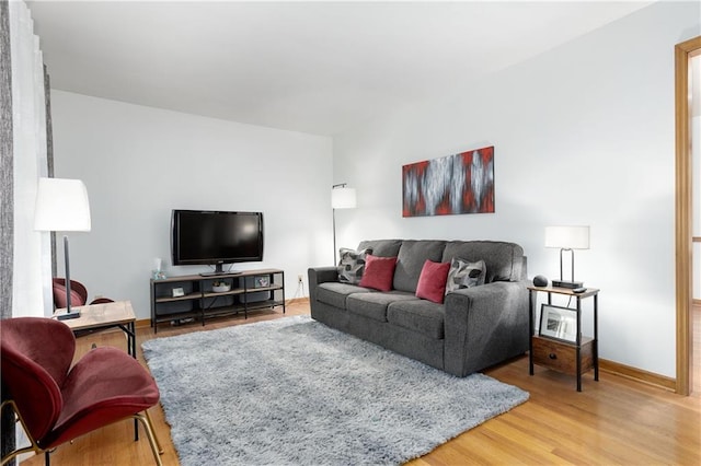 living area with baseboards and wood finished floors