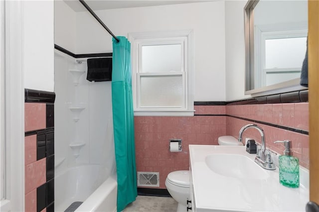 bathroom with visible vents, toilet, shower / bath combination with curtain, vanity, and tile walls