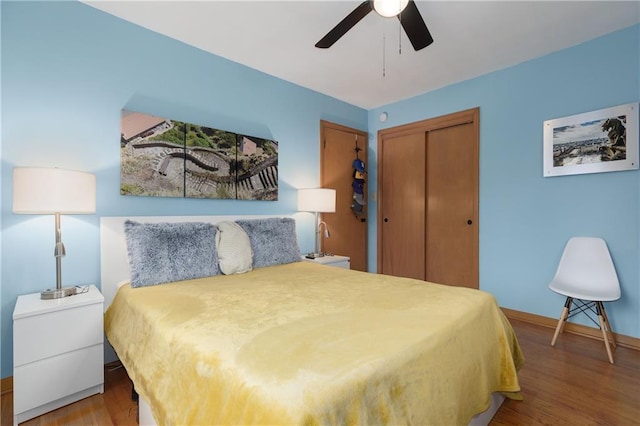 bedroom featuring a ceiling fan, baseboards, a closet, and wood finished floors