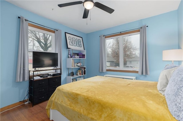 bedroom featuring dark wood-style flooring, a ceiling fan, and baseboards