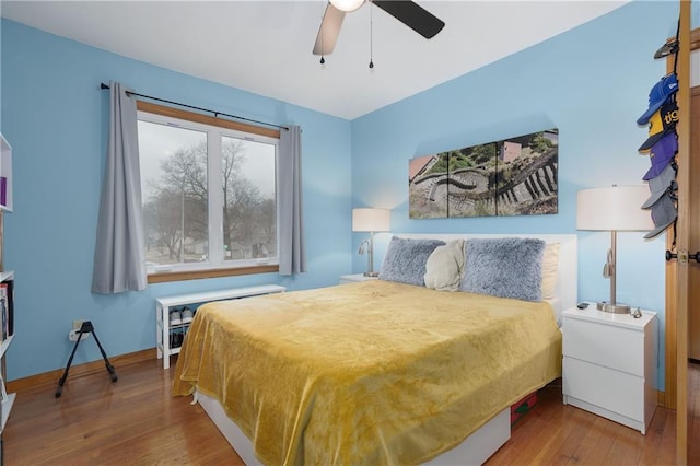 bedroom featuring ceiling fan, wood finished floors, and baseboards