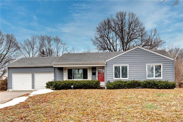 ranch-style home with driveway, a shingled roof, an attached garage, and a front yard