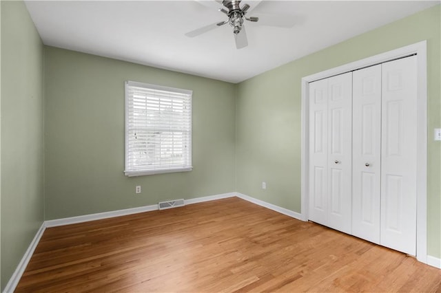 unfurnished bedroom with ceiling fan, hardwood / wood-style floors, and a closet