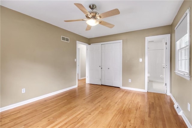 unfurnished bedroom featuring a closet, ceiling fan, ensuite bath, and light hardwood / wood-style flooring