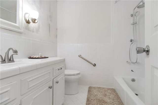 full bathroom featuring tile walls, tile patterned flooring, vanity, toilet, and tiled shower / bath