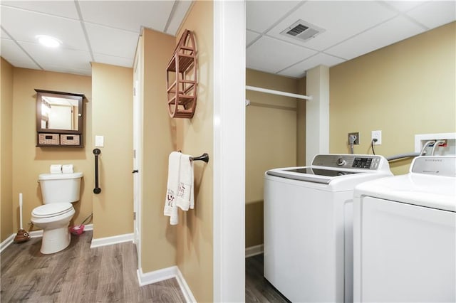 clothes washing area with hardwood / wood-style flooring and washer and clothes dryer