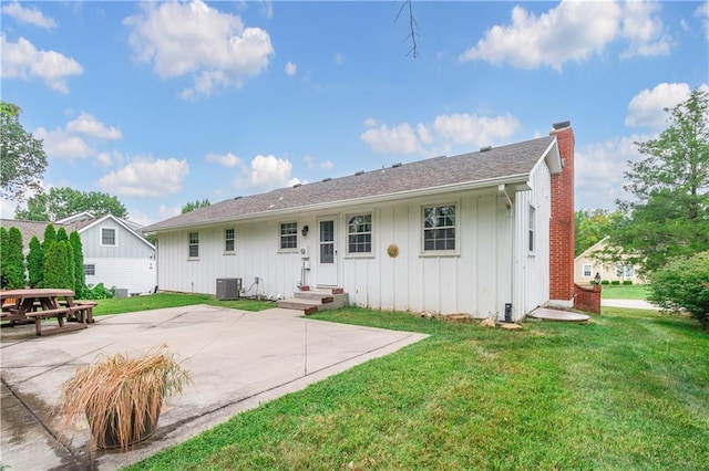 back of property featuring central AC, a patio area, and a lawn