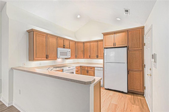 kitchen with lofted ceiling, white appliances, light hardwood / wood-style flooring, and kitchen peninsula