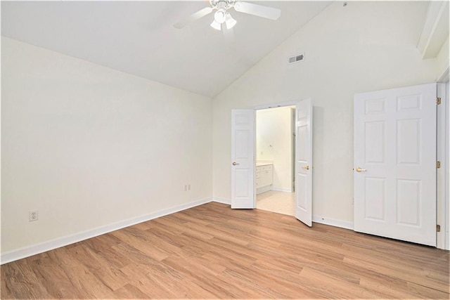 unfurnished bedroom with ceiling fan, ensuite bath, high vaulted ceiling, and light wood-type flooring