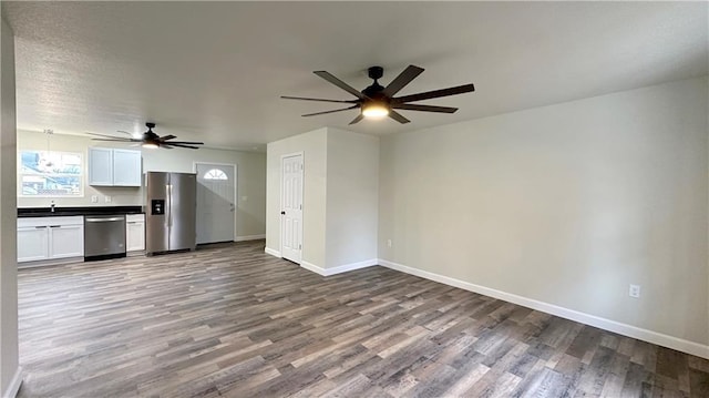 unfurnished living room with sink, hardwood / wood-style flooring, and ceiling fan