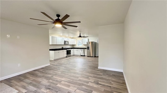 unfurnished living room with wood-type flooring and ceiling fan