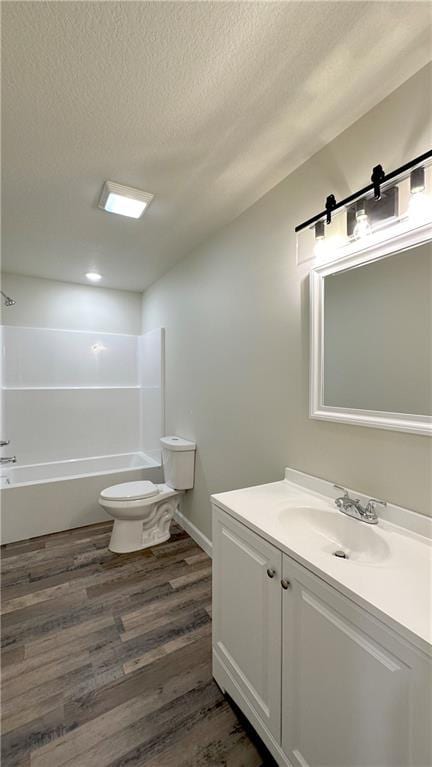 full bathroom with vanity, wood-type flooring, a textured ceiling, shower / bathtub combination, and toilet