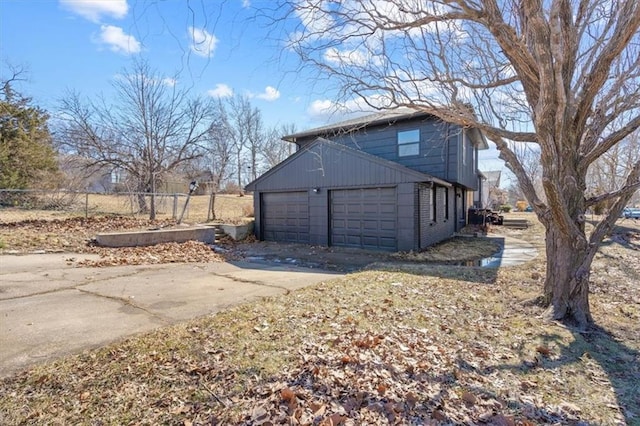 7901 Hedges Ave, Raytown, MO 64138 - view of side of property featuring concrete driveway, fence, and a garage