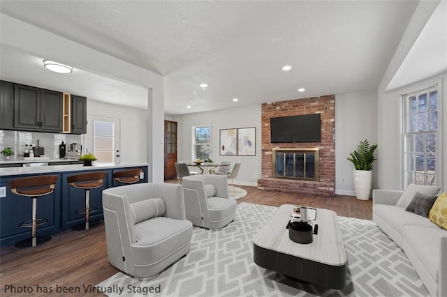 7901 Hedges Ave, Raytown, MO 64138 - living area featuring a wealth of natural light, recessed lighting, a fireplace, and wood finished floors