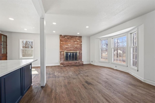 7901 Hedges Ave, Raytown, MO 64138 - unfurnished living room featuring dark wood-type flooring, plenty of natural light, and baseboards