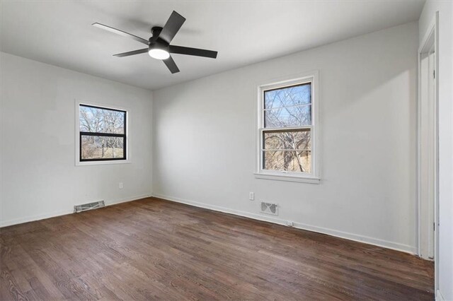7901 Hedges Ave, Raytown, MO 64138 - unfurnished room with dark wood-type flooring, baseboards, visible vents, and ceiling fan