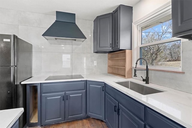 7901 Hedges Ave, Raytown, MO 64138 - kitchen with black appliances, a sink, wall chimney exhaust hood, light countertops, and decorative backsplash