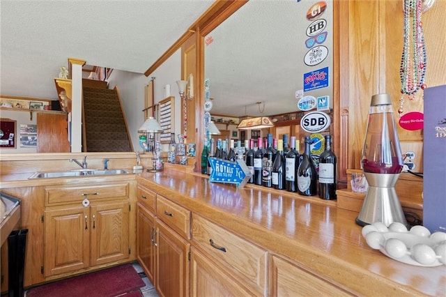 kitchen with butcher block counters, sink, kitchen peninsula, and a textured ceiling