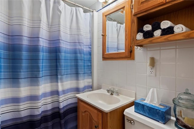 bathroom featuring tasteful backsplash, vanity, toilet, and tile walls