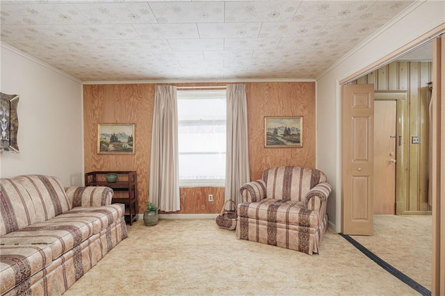 carpeted living room with wood walls, baseboards, and ornamental molding