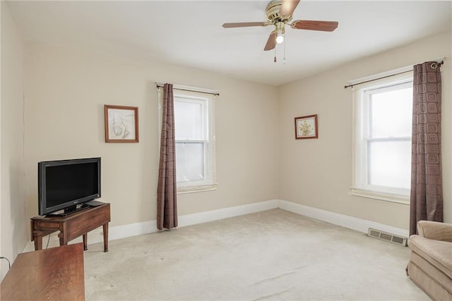 sitting room featuring light carpet, a ceiling fan, visible vents, and baseboards