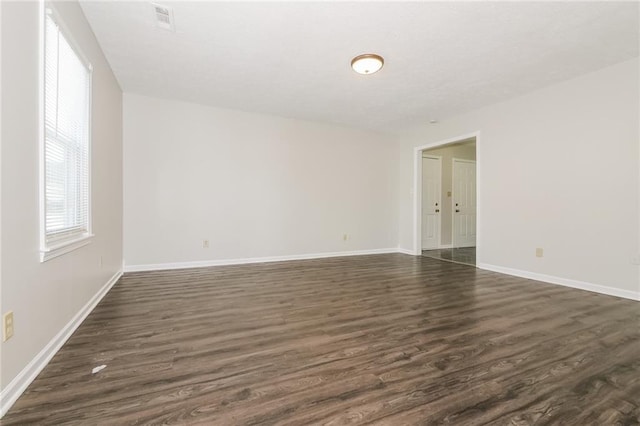 unfurnished room featuring dark wood-type flooring