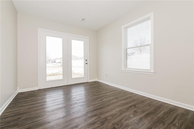 empty room with a healthy amount of sunlight and dark hardwood / wood-style floors