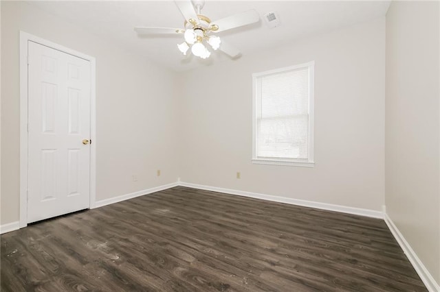 spare room featuring dark wood-type flooring and ceiling fan