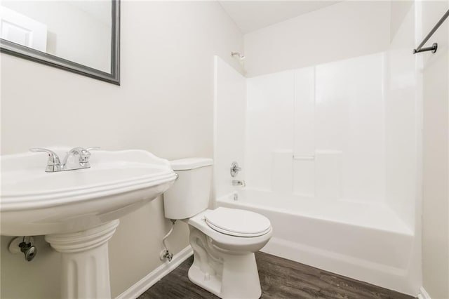 bathroom featuring hardwood / wood-style flooring, shower / bathing tub combination, and toilet