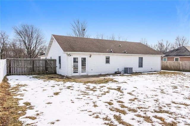 snow covered property with cooling unit and french doors