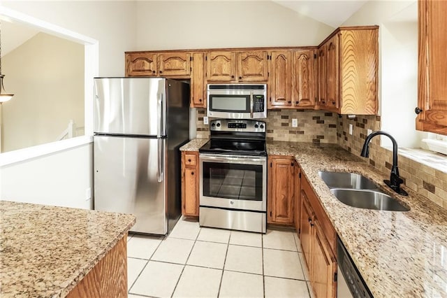 kitchen featuring vaulted ceiling, tasteful backsplash, sink, stainless steel appliances, and light stone countertops