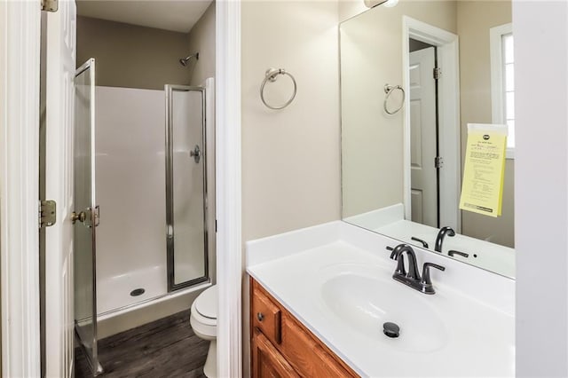 bathroom with vanity, wood-type flooring, toilet, and walk in shower