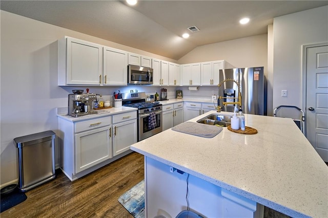 kitchen with light stone counters, stainless steel appliances, and white cabinets