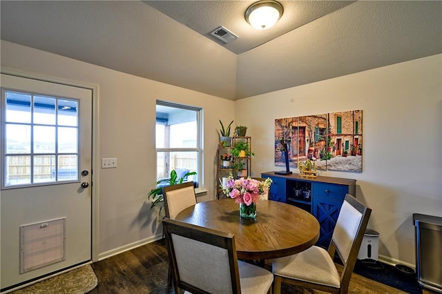 dining space with vaulted ceiling and dark hardwood / wood-style floors