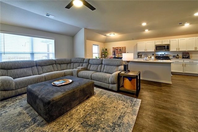 living room with lofted ceiling, ceiling fan, dark hardwood / wood-style flooring, and a healthy amount of sunlight