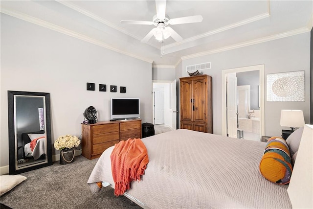 carpeted bedroom featuring connected bathroom, ornamental molding, and a raised ceiling