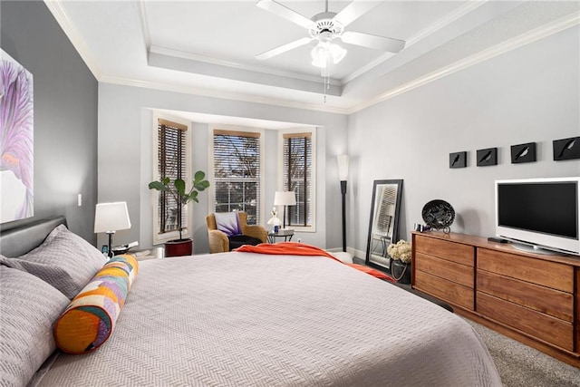 bedroom with crown molding, ceiling fan, and a tray ceiling