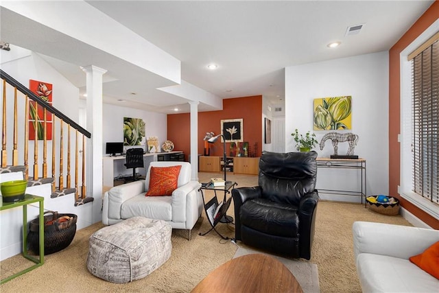 living room with decorative columns and light carpet