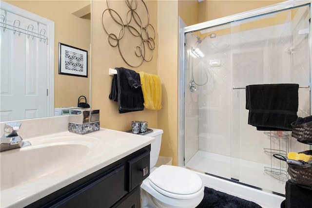 bathroom featuring an enclosed shower, vanity, and toilet