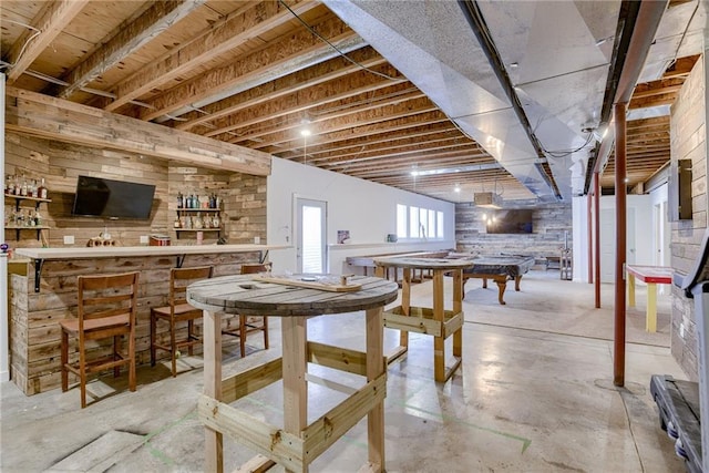 dining area with concrete flooring and a bar